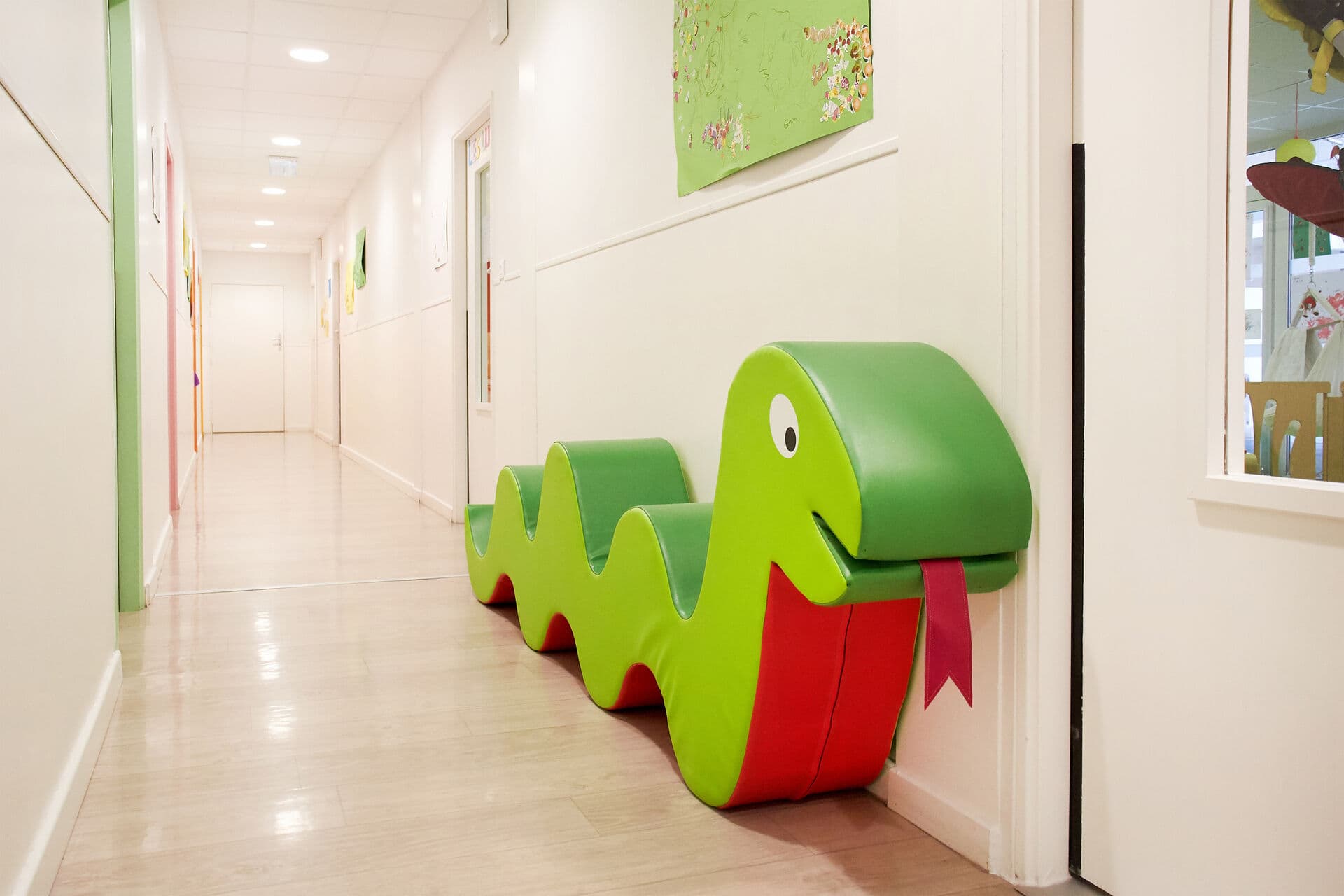 Le couloir de L'Éveil et son banc serpent, décoré des créations des enfants